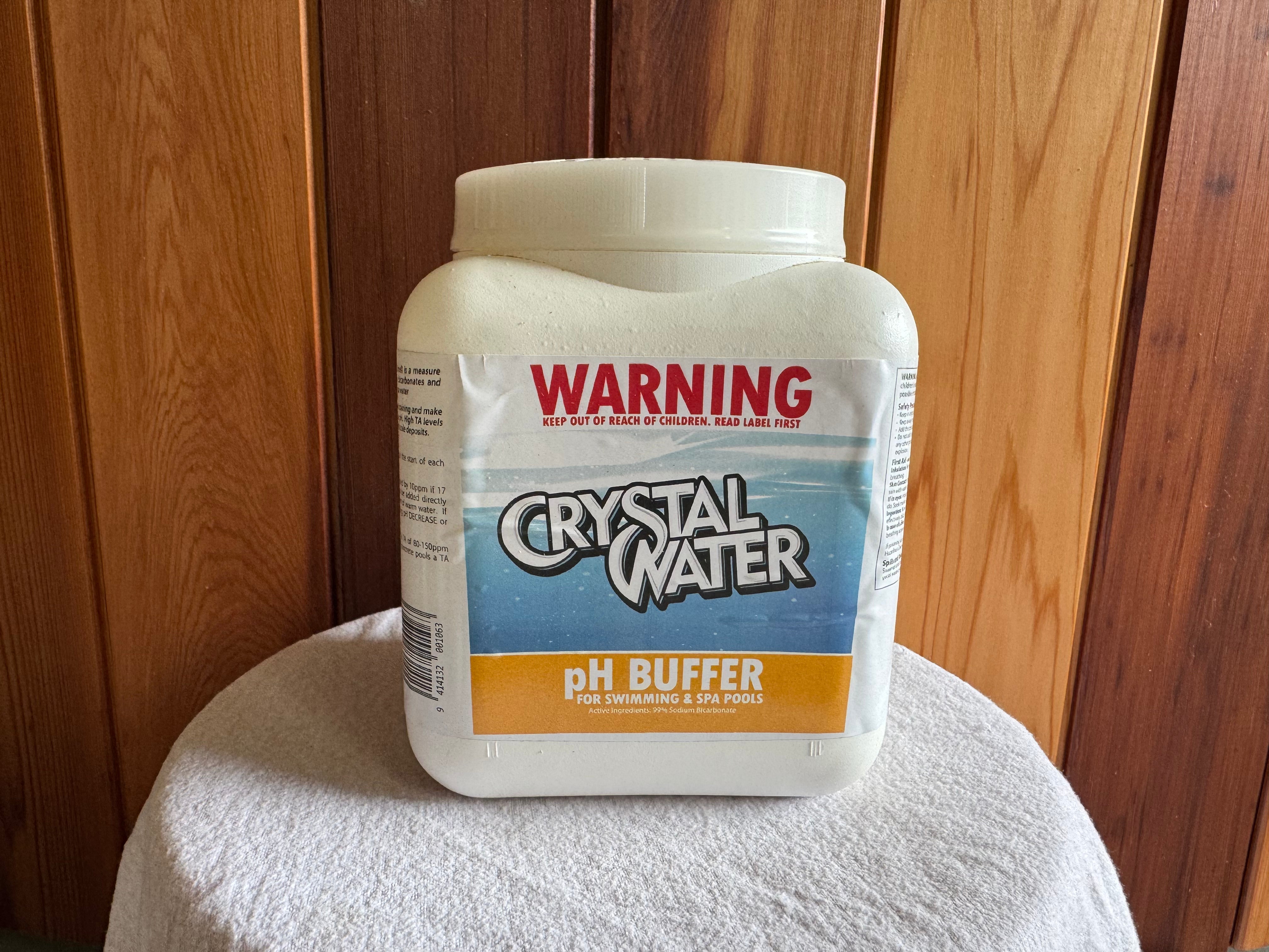 A plastic container labeled 'CRYSTAL WATeR pH Buffer' for pool and spa maintenance.