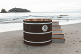 Barrel-shaped hot tub on a sandy beach with ocean view, Sulis Hot Tub