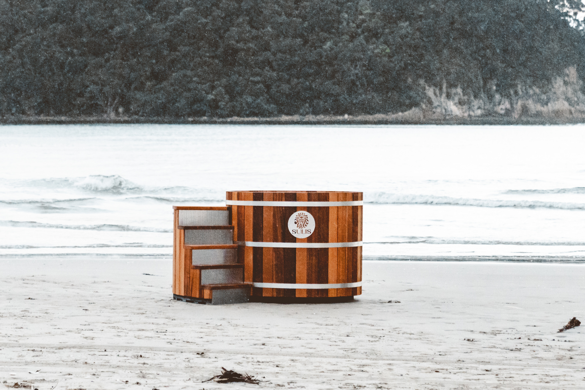 Wooden barrel with a logo on a snowy landscape, Sulis Hot Tubs