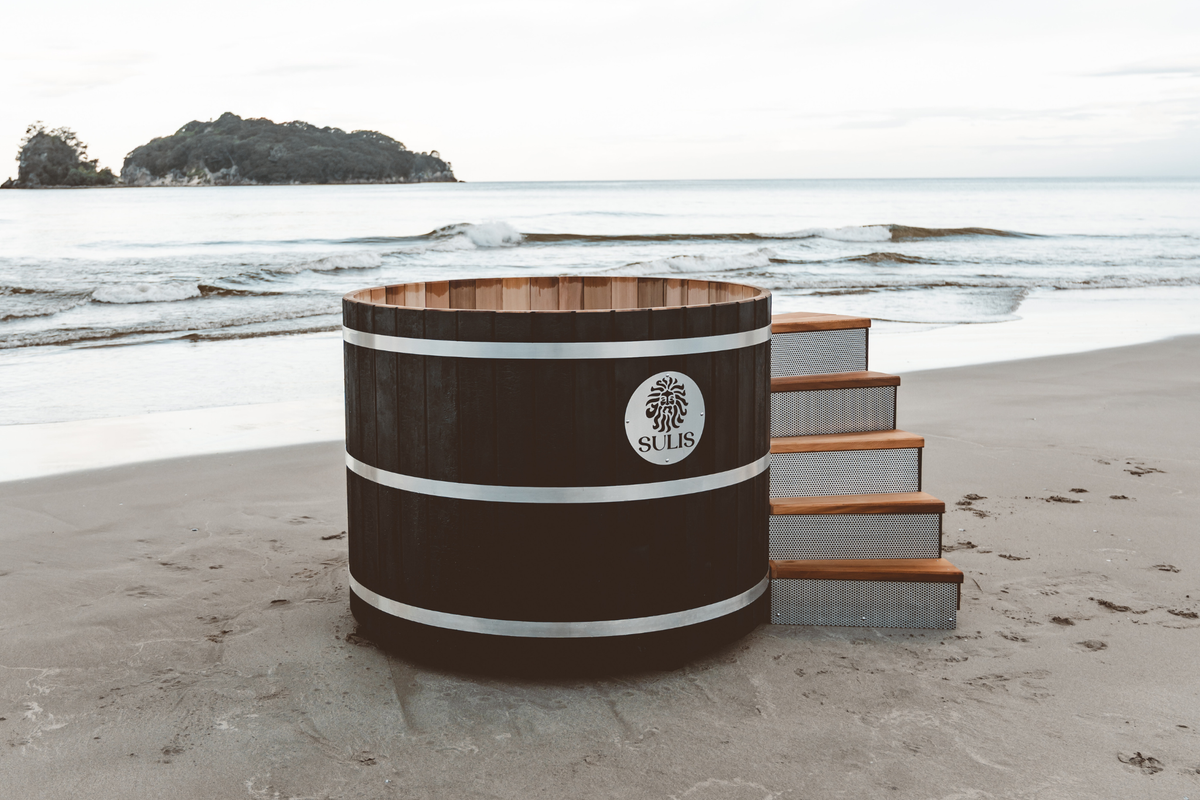 Barrel-shaped hot tub on a sandy beach with ocean view, Sulis Hot Tub