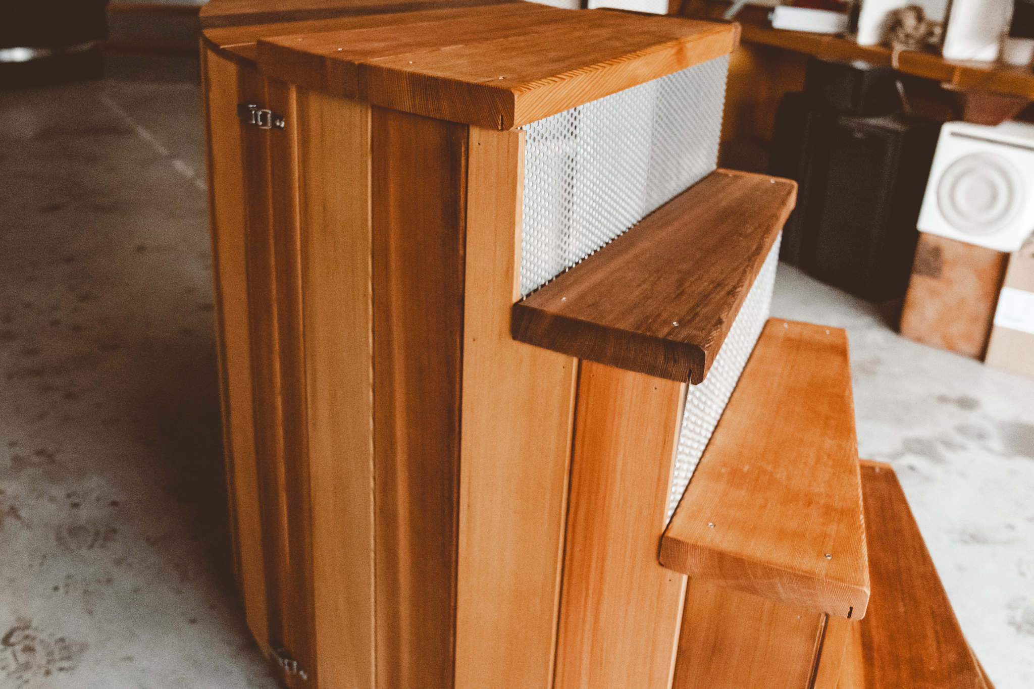 Wooden step stool with multiple steps on a concrete floor. Sulis hot tubs