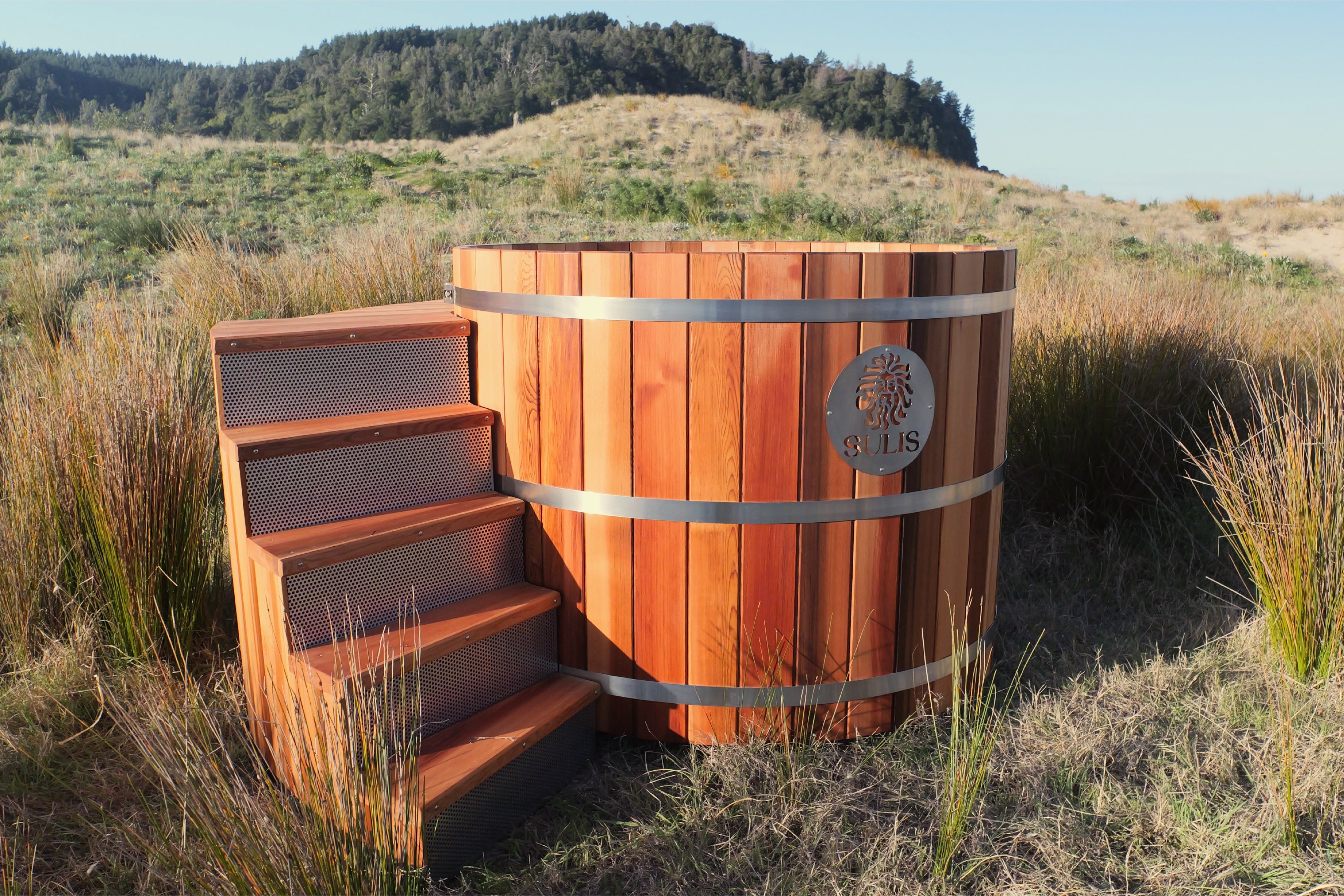 Wooden Cedar Sulis hot tub with steps in a natural outdoor setting
