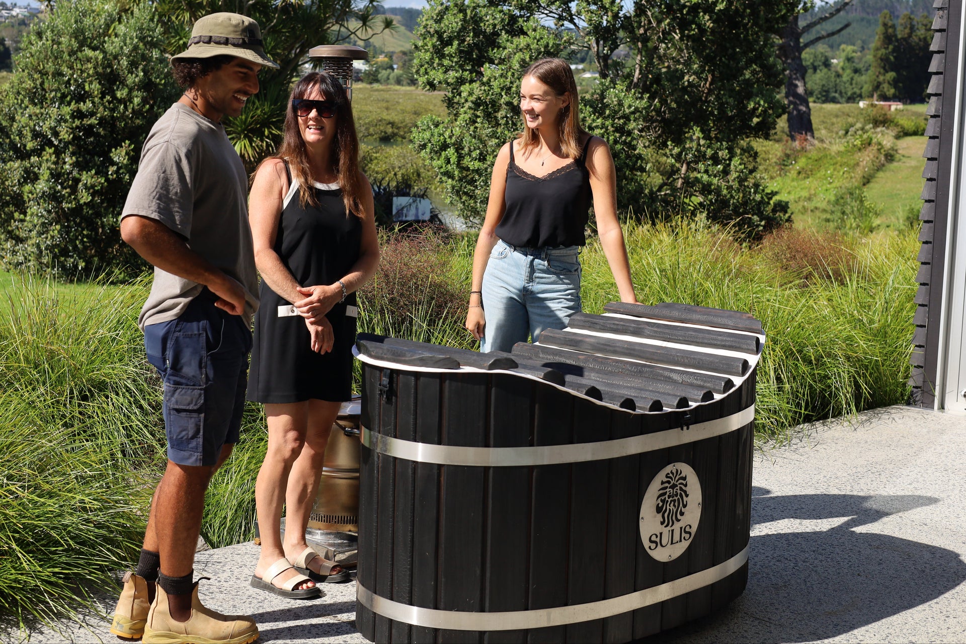 Reuben O'Neill with happy customers in front of a black hot tub