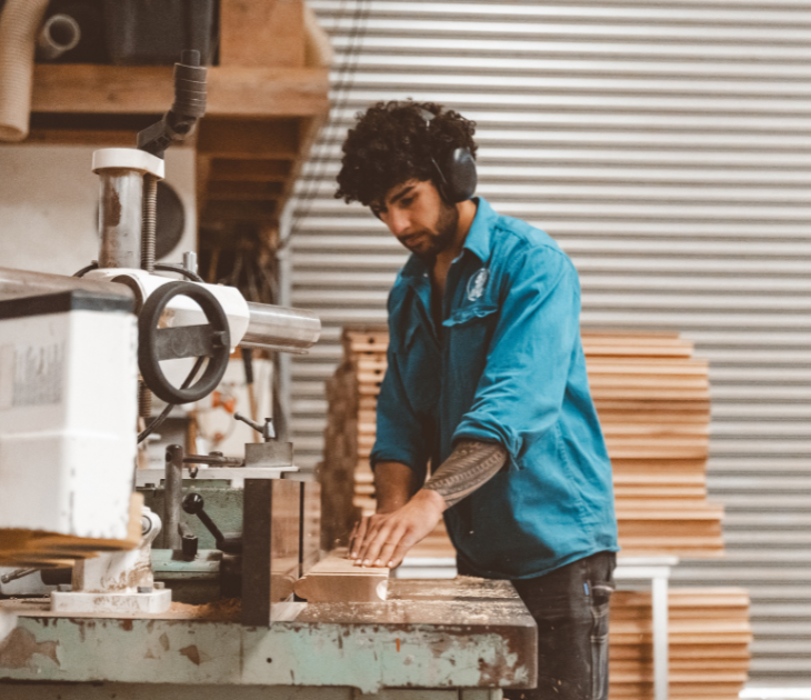 Man working with wood in a workshop, attention to detail, creating sulis hot tub